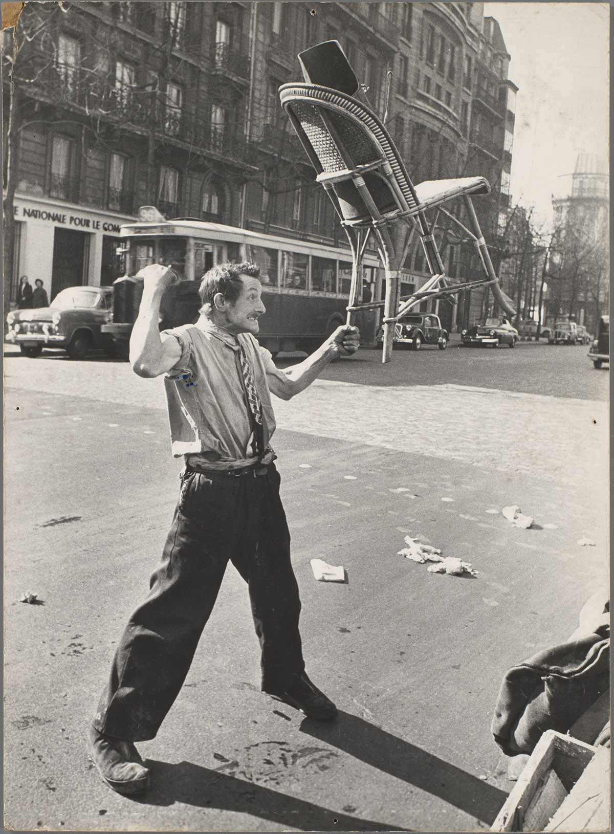Ed van der Elsken, Straatartiest houdt stoel in de lucht, Parijs, ca. 1951 (afgedrukt voor 1959). Rijksmuseum, Amsterdam. Langdurig bruikleen van Anneke Hilhorst, Warder, 2019, erven Ed van der Elsken/Nederlands Fotomuseum