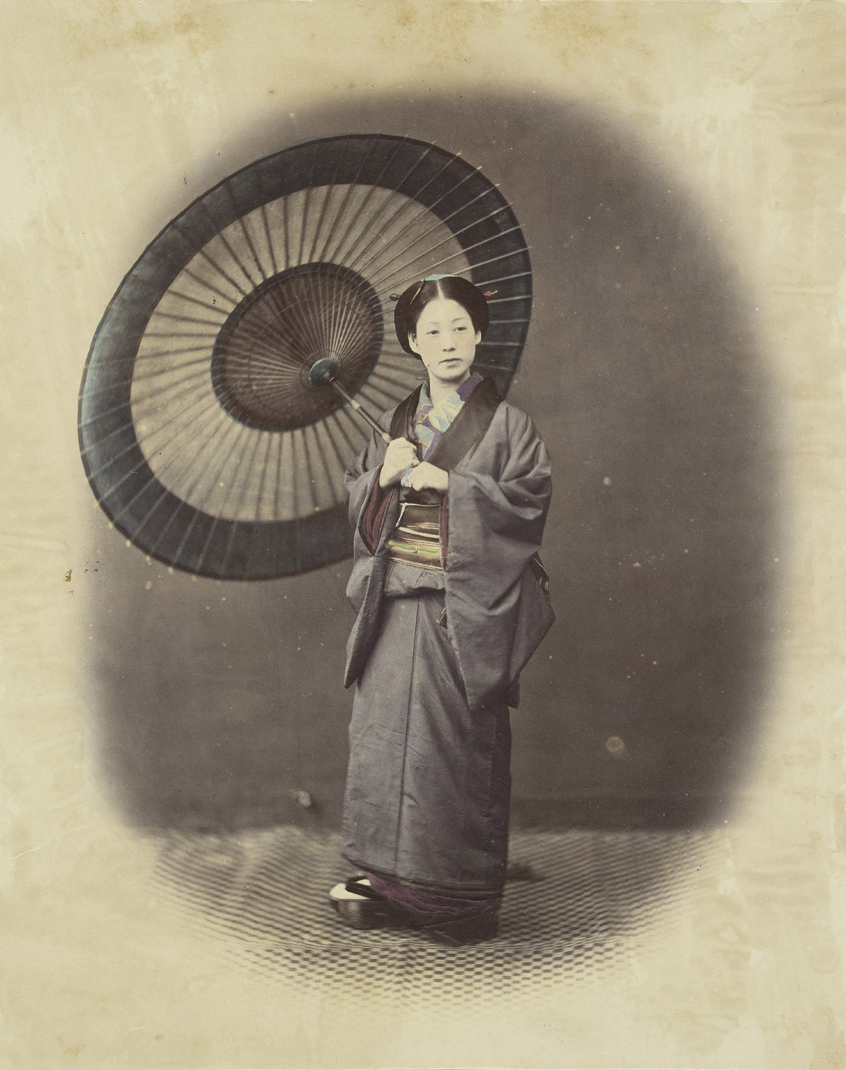 Ingekleurde foto van een Japanse vrouw met een parasol, 1867, Felice Beato / Collectie Het Scheepvaartmuseum, Amsterdam